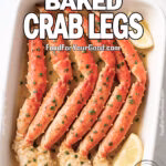 Garlic Butter Baked Crab Legs served in a white dish with lemon and parsley on marble background.