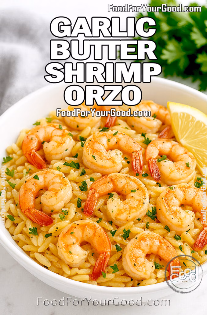 A bowl of garlic butter shrimp orzo on a marble counter with fresh parsley and lemon