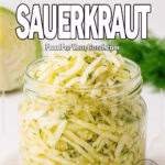 Glass jar filled with homemade garlic dill sauerkraut on a linen napkin with fresh cabbage and dill in the background