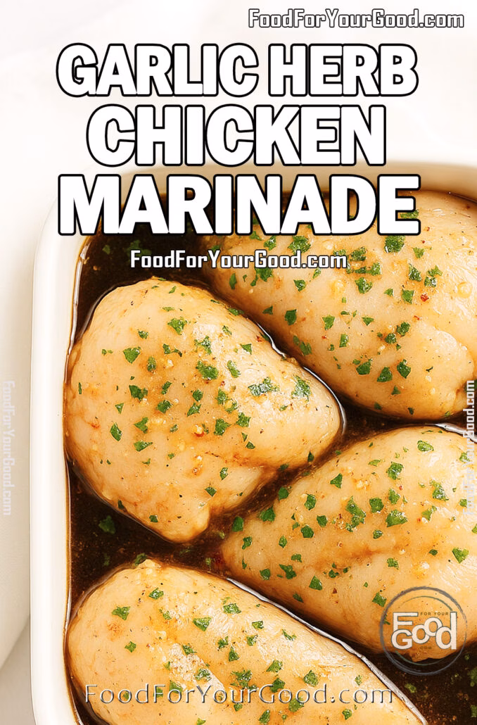 Raw chicken thighs marinating in garlic herb sauce inside a white square ceramic baking dish, placed on a marble surface with a soft white towel