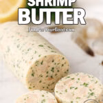 Garlic Herb Shrimp Butter log with slices on white marble, with lemon, parsley, and raw shrimp in the blurred background.