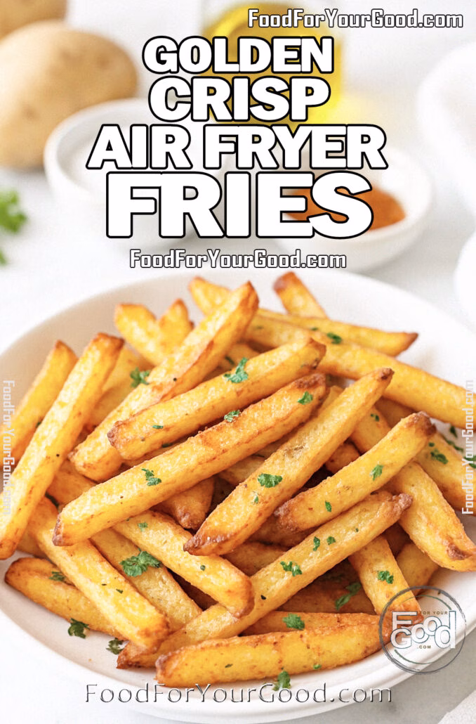 Golden Crisp Air Fryer Fries Golden Crisp Air Fryer Fries in a white bowl, garnished with parsley, on a marble countertop with potatoes and spices blurred in the background.