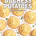 Golden Duchess Potatoes baked with rustic homemade swirls, crisp edges, and fresh herbs on white marble.