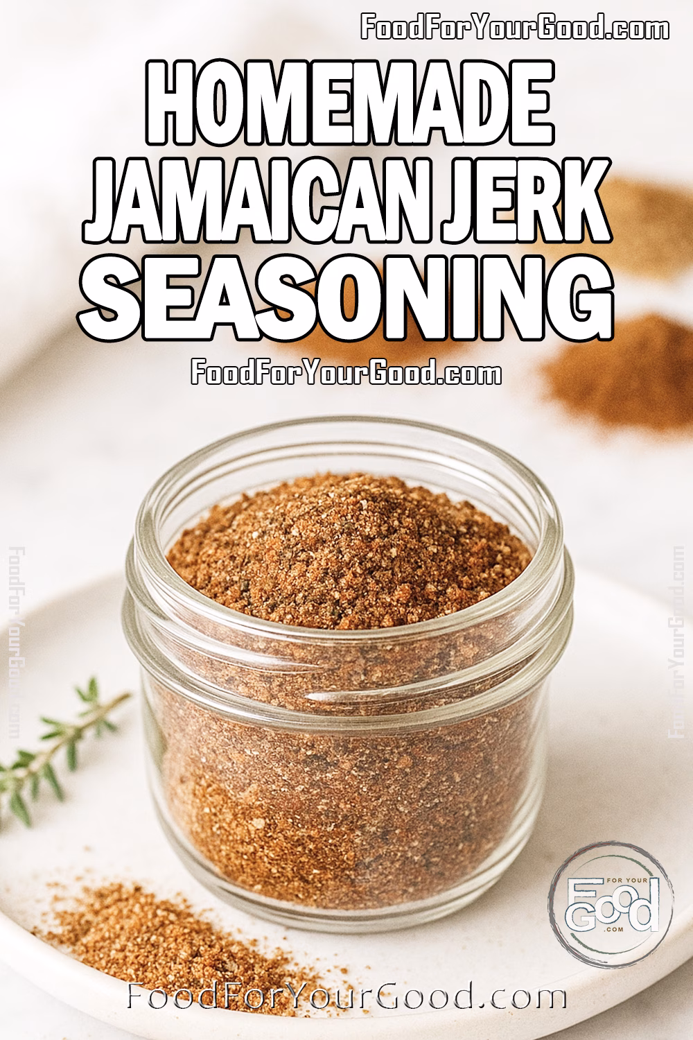 Homemade Jamaican Jerk Seasoning Recipe – FoodForYourGood.com Homemade Jamaican Jerk Seasoning in a glass jar with fresh herbs and peppers on marble at FoodForYourGood.com