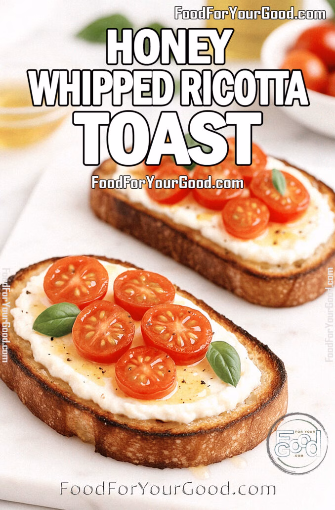 Honey Whipped Ricotta Toast with cherry tomatoes and basil on artisan bread, served on a marble cutting board with olive oil and tomatoes in the background.