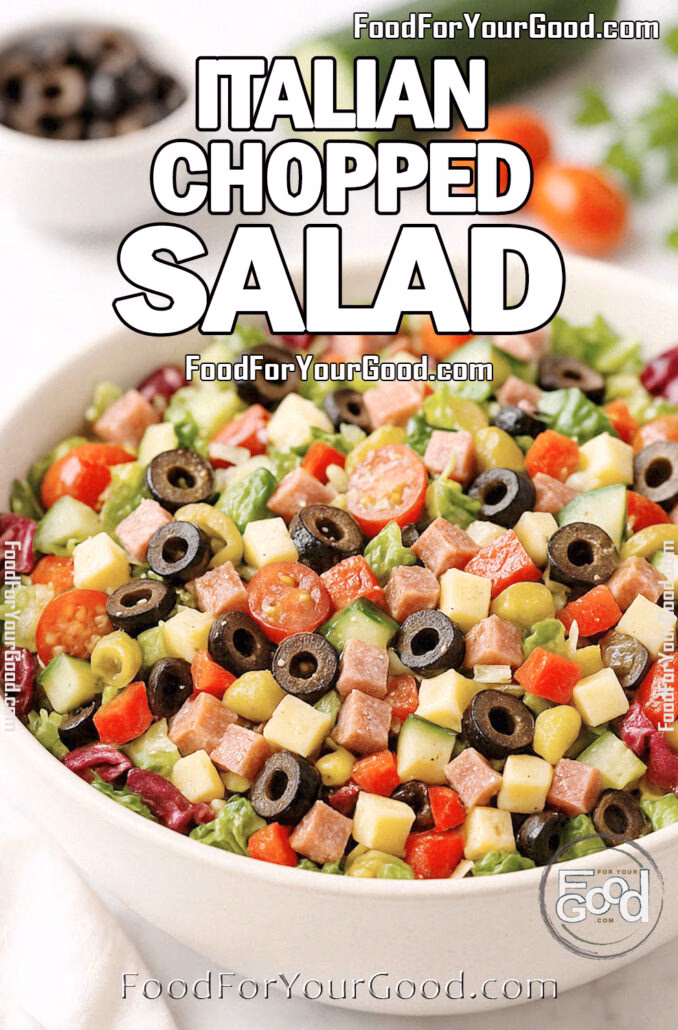 Italian Chopped Salad Italian Chopped Salad in a white bowl with fresh vegetables, salami, cheese, and olives on marble countertop.