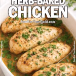 Juicy Herb-Baked Chicken in a white oval baking dish, garnished with parsley, resting in golden juices on a marble countertop with fresh herbs in the background.