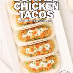 Loaded Buffalo Chicken Tacos neatly arranged on a white rectangular platter with fresh toppings, photographed on a marble surface at FoodForYourGood.com