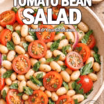 Mediterranean Tomato Bean Salad with cherry tomatoes, white beans, fresh basil, and red onion, glistening with vinaigrette in a rustic ceramic bowl.