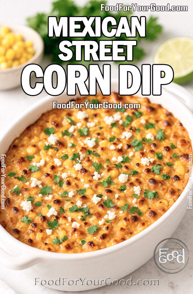 Mexican Street Corn Dip baked in a white dish, topped with Cotija cheese and cilantro, on marble with lime and corn.