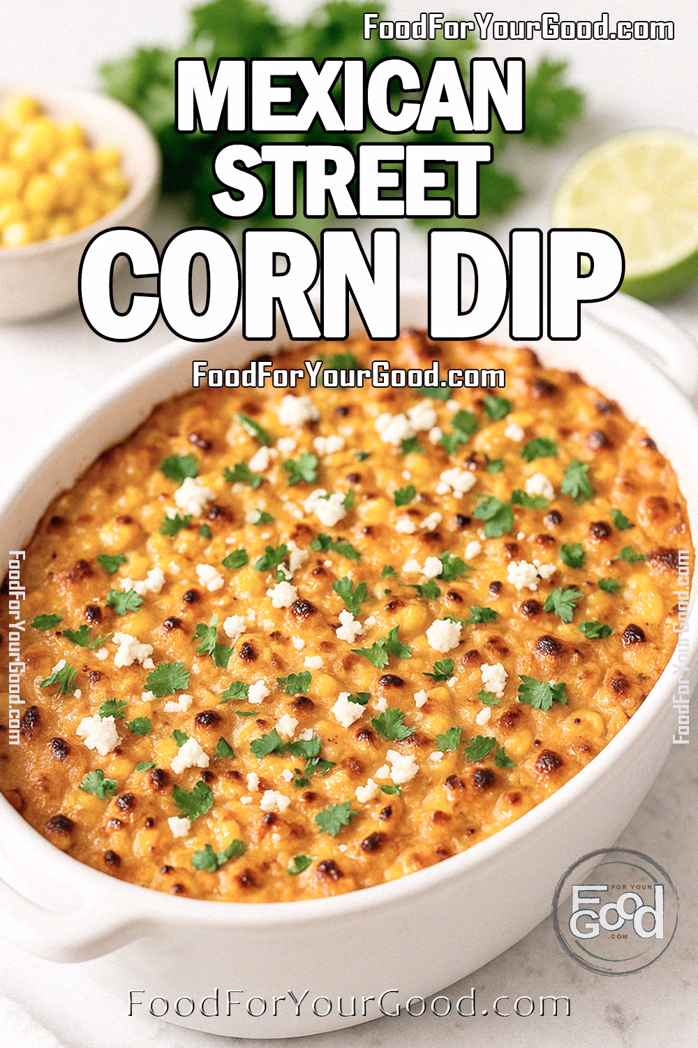 Mexican Street Corn Dip baked in a white dish, topped with Cotija cheese and cilantro, on marble with lime and corn.