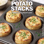 Mini Gratin Potato Stacks baked in a metal muffin tin, golden brown with crisp edges and sprinkled with chives, on a white marble countertop.
