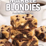 Mocha Marble Blondies stacked on a white marble surface, showing swirls of chocolate and blondie batter with chocolate chips, next to a cup of coffee and a small creamer.