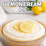 Homemade No-Bake Lemon Cream Pie with whipped cream topping, fresh lemon slices, and zest on a graham cracker crust, styled on a white marble countertop.