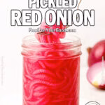 A jar of quick pickled red onions being lifted with a fork, placed on a white towel with halved red onions in the blurred marble background.