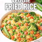 Rainbow Veggie Fried Rice in a white ceramic bowl with broccoli, carrots, peas, snap peas, and scrambled eggs on a marble countertop, styled for FoodForYourGood.com
