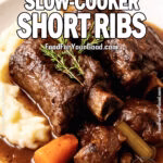 Red Wine Braised Slow-Cooker Short Ribs served with mashed potatoes, carrots, and celery, garnished with fresh rosemary and thyme on a white marble countertop.