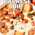 Roasted Garlic Caprese Dip baked with melted cheese, cherry tomatoes, basil, and toasted bread slices in a white dish on FoodForYourGood.com