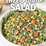 Roasted Sweet Potato Salad with arugula, chickpeas, feta, and pumpkin seeds served in a white marble bowl on FoodForYourGood.com