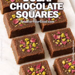 Homemade Royal Dubai Chocolate Squares topped with pistachios and rose petals on a marble tray