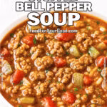 Close-up of Rustic Stuffed Bell Pepper Soup in a white bowl, filled with ground beef, diced bell peppers, tomatoes, and rice in a rich tomato broth, garnished with fresh parsley, on a white marble surface.