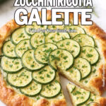 Rustic zucchini ricotta galette with golden flaky crust, layered zucchini slices, and fresh herbs on a white marble surface, photographed in bright daylight.