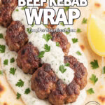 Smashed Beef Kebab Wrap with cucumber yogurt sauce, juicy beef patties in warm flatbread with parsley and lemon on marble.