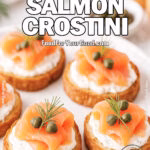 Smoked Salmon Crostini on a round white plate, with golden baguette slices topped with cream cheese, smoked salmon, capers, and dill, styled on a marble background.