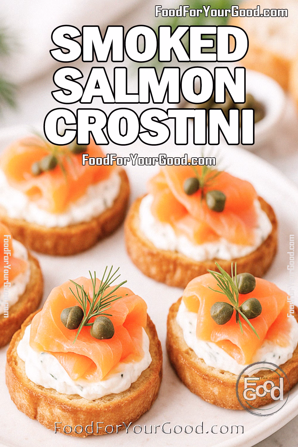 https://www.foodforyourgood.com/appetizers-and-salads/smoked-salmon-crostini.html Smoked Salmon Crostini on a round white plate, with golden baguette slices topped with cream cheese, smoked salmon, capers, and dill, styled on a marble background.