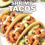 Smoky Chipotle Shrimp Tacos with avocado, red cabbage, cotija cheese, and chipotle-lime crema on a white rectangular plate from FoodForYourGood.com