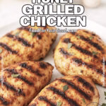 Smoky Honey Grilled Chicken on a white plate, garnished with parsley and photographed on a marble countertop with fresh herbs and garlic in the background.