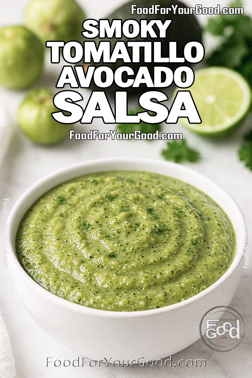 Smoky Tomatillo Avocado Salsa Recipe | FoodForYourGood.com A bowl of Smoky Tomatillo Avocado Salsa on a white marble countertop, with fresh tomatillos, avocado, lime, cilantro, and a white towel in the background.