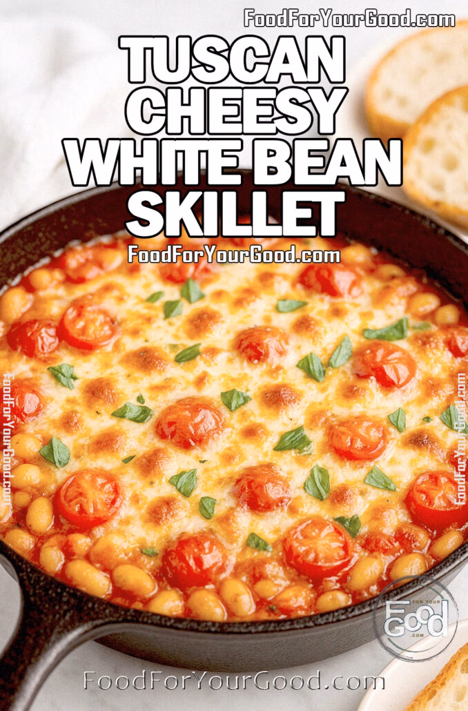 Tuscan Cheesy White Bean Skillet in a cast iron pan with golden melted cheese, cherry tomatoes, and basil, served with crusty bread on a marble countertop.