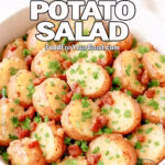 Warm German Potato Salad with bacon vinaigrette and herbs in a white serving bowl