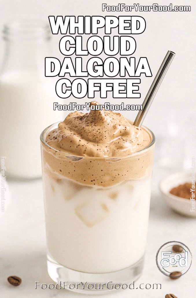 Whipped Cloud Dalgona Coffee Whipped Cloud Dalgona Coffee in a clear glass with a messy whipped topping, straw inserted, served on a white marble countertop with blurred milk bottle, cocoa powder, ice cubes, and a white towel in the background on FoodForYourGood.com
