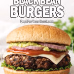 Best-Ever Black Bean Burgers stacked on a bun with fresh toppings on FoodForYourGood.com