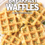 Cheddar Herb Breakfast Waffles served golden and crispy on a white plate, garnished with fresh herbs, styled on marble in bright daylight.