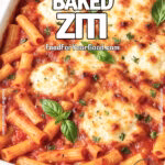 Classic Baked Ziti with Three Cheeses in a white ceramic baking dish on a white marble countertop, topped with golden melted cheese and fresh basil, with a white towel and herbs blurred in the background.