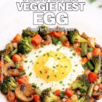 Five Minute Air Fryer Veggie Nest Egg on FoodForYourGood.com with crispy browned vegetables, egg in the center, melting butter, Parmesan, and chives.