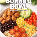 Loaded Burrito Bowl with chicken, black beans, corn, avocado, cheese, and rice served in a white bowl on marble background