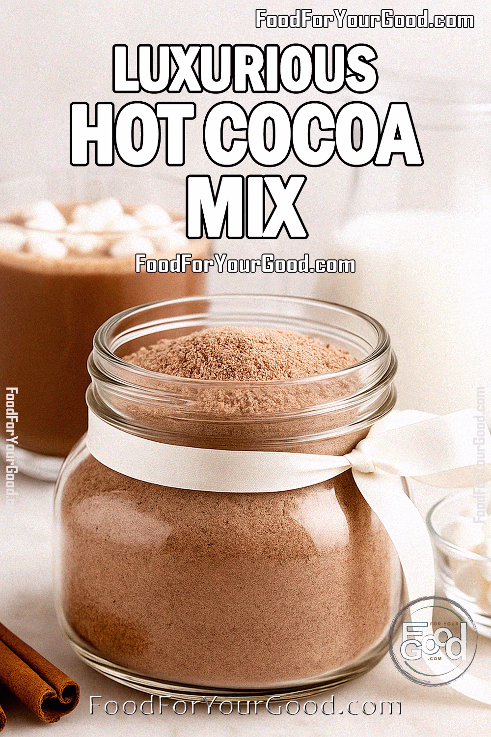 Luxurious Hot Cocoa Mix in a wide glass jar with a white ribbon, styled with a steaming mug of hot cocoa topped with marshmallows, a modern glass pitcher of milk, and cinnamon sticks on a white marble background.