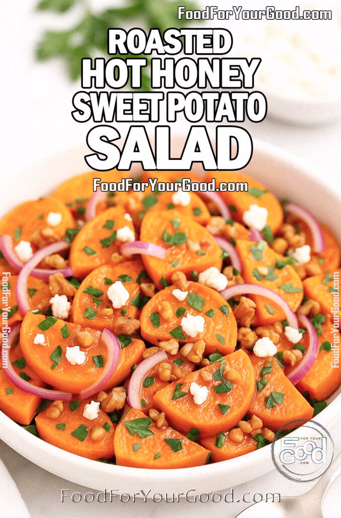Roasted Hot Honey Sweet Potato Salad in a white ceramic bowl with sweet potato slices, red onion, feta, walnuts, and parsley on a marble background with a silver spoon.
