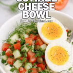 Savory Cottage Cheese Bowl in a white round bowl with creamy cottage cheese, diced cucumbers, diced tomatoes, dill, chives, red onion, capers, and two soft-cooked egg halves. Fresh cucumber slices, tomato wedges, and dill sprigs are softly blurred in the background on a marble surface.