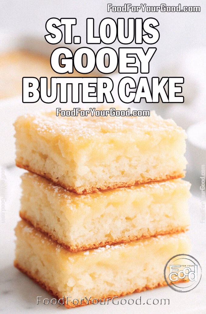 St. Louis Gooey Butter Cake St. Louis Gooey Butter Cake squares stacked on a white marble tray with a soft, fluffy cake base and a slightly uneven baked cream cheese top, dusted with powdered sugar. A white baking pan with more cake is blurred in the background, styled with a white towel and powdered sugar bowl